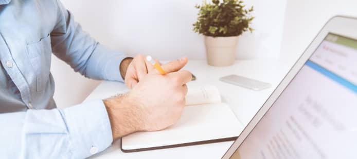 Personne prenant des notes à un bureau