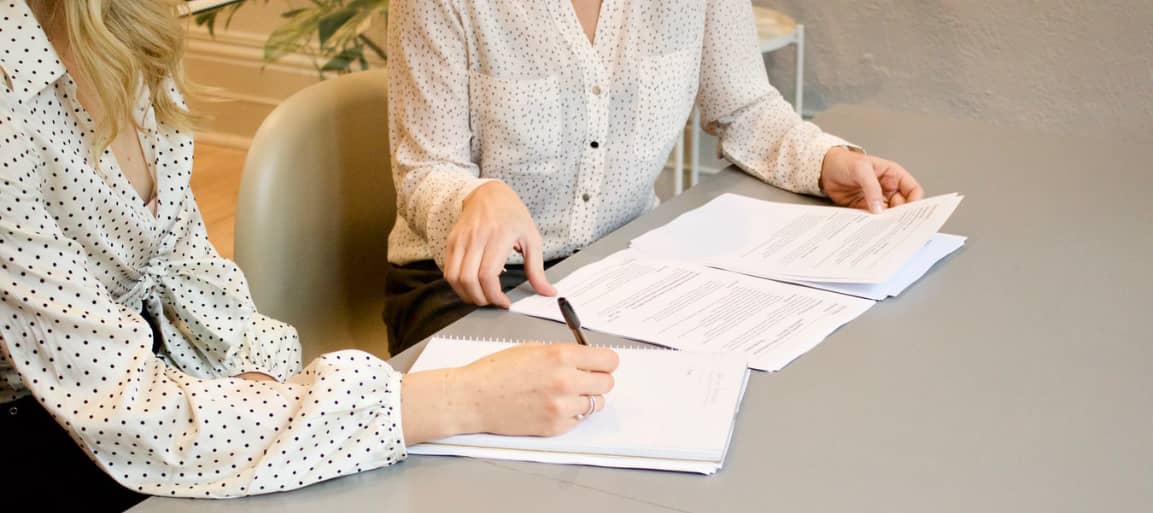 personne écrivant sur une feuille