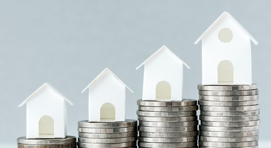 Image de petite maisons sur des piles de pièces